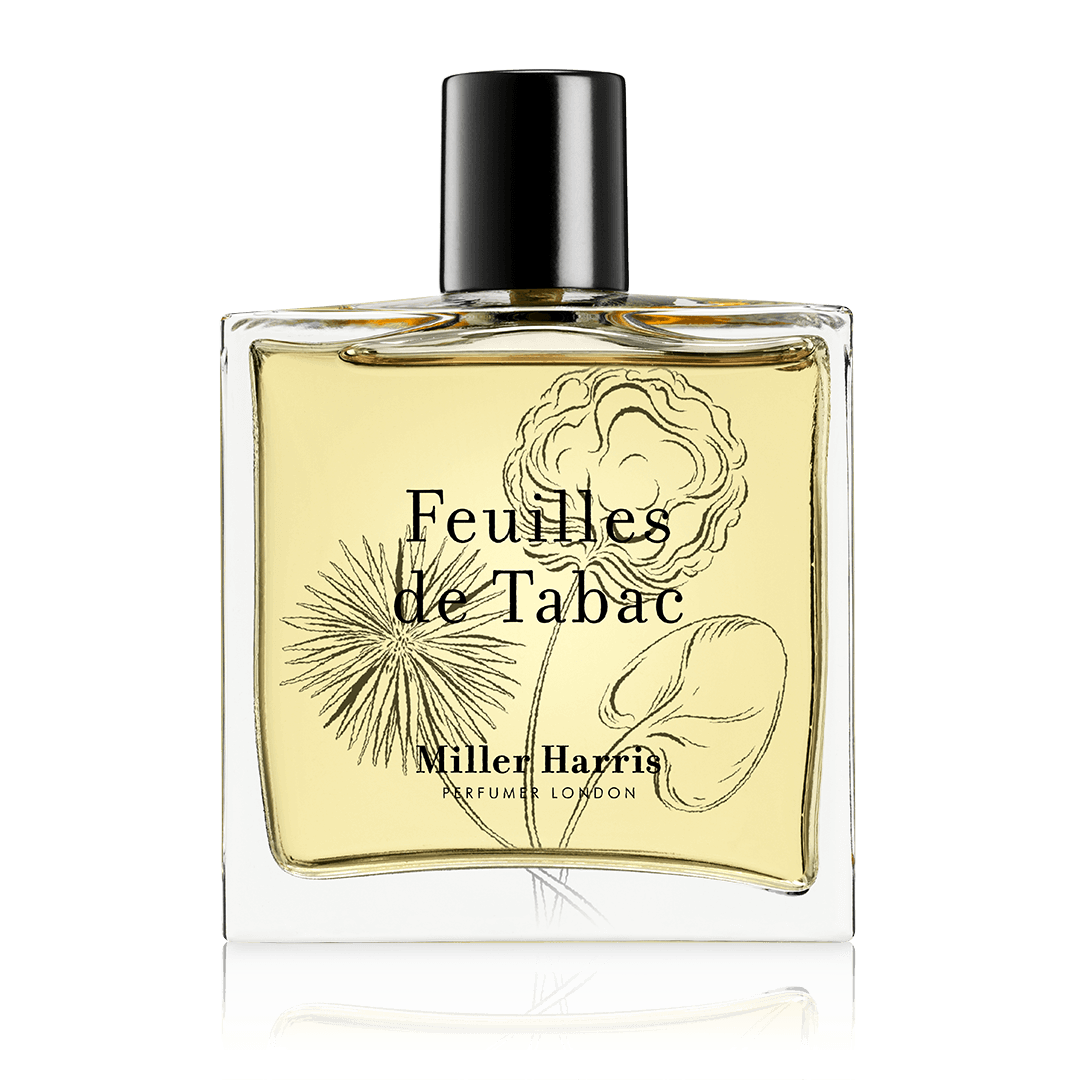 A clear glass bottle of Feuilles de Tabac eau de parfum with a black cap and cream label.
